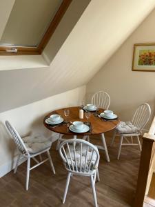 a dining room with a wooden table and chairs at The Loft, Steep, Petersfield in Collyers Estate part of The South Downs National Park. in Petersfield