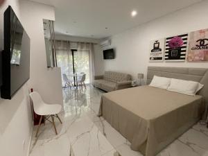 a bedroom with a bed and a living room at Estudio Balaia by Villas Key in Albufeira