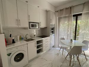 a kitchen with a washing machine and a table at Estudio Balaia by Villas Key in Albufeira