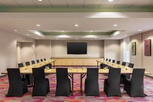 a conference room with tables and chairs and a flat screen tv at Home2 Suites by Hilton Lubbock in Lubbock