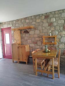 a dining room with a table and a stone wall at Tropical Garden Prime Accommodation in Faliraki