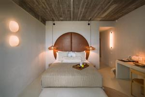 a bedroom with a large bed with a wooden headboard at Euforia Retreat and Spa in Eforie Nord