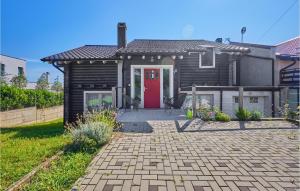 a house with a red door and a patio at Nice Home In Bregana With House A Panoramic View in Bregana