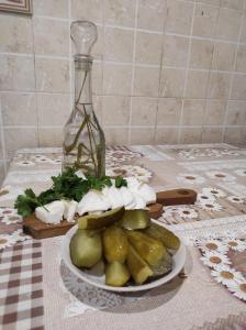 a plate of vegetables on a table with a bottle at Nad Cheremoshem in Tyudov