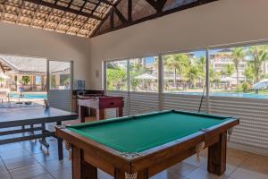 a room with a pool table and two tables at Portamaris Resort #101 - Apartamento de Luxo em Porto das Dunas Por Carpediem in Aquiraz