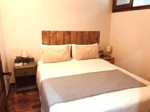 um quarto com uma cama grande e uma cabeceira em madeira em Acogedor apartamento en Llivia em Llivia