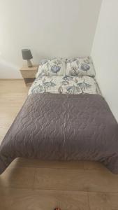 uma cama com um edredão cinzento num quarto em Apartament "Cztery Pory Roku" em Świdnik