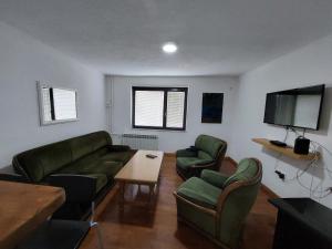 un soggiorno con mobili verdi e TV a schermo piatto di Hostel Bobito a Sarajevo
