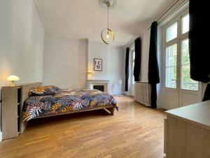 ein Schlafzimmer mit einem Bett mit einer bunten Decke darauf in der Unterkunft Le Varsovie ※ 4 balcons in Carcassonne