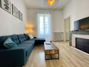 ein Wohnzimmer mit einem blauen Sofa und einem Kamin in der Unterkunft Le Varsovie ※ 4 balcons in Carcassonne