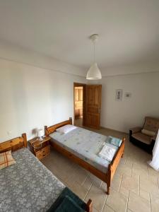 ein Schlafzimmer mit einem großen Bett und einem Stuhl darin in der Unterkunft Villas Nies in Soúrpi