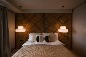 una camera da letto con una grande testiera in legno e due lampade a sospensione di Euforia Retreat and Spa a Eforie Nord