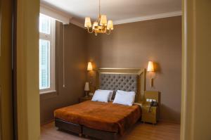 a bedroom with a bed and a chandelier at Delphi Art Hotel by Prima Hotels in Athens