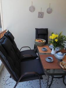 a dining room table with two chairs and a table with flowers at Argostoli Elia's Maisonette in Argostoli