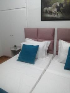 a bed with blue and white pillows on it at Argostoli Elia's Maisonette in Argostoli