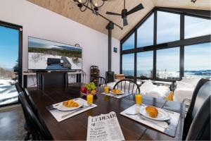a dining room with a table with food on it at Chalet du bois flotté in La Malbaie