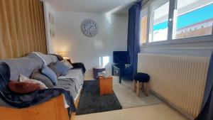 uma sala de estar com um sofá e um relógio na parede em Spacieux appartement Tignes le Lac em Tignes