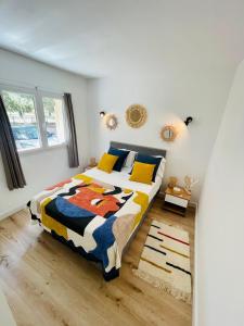 een slaapkamer met een bed met een koeiensprei erop bij Cala Rossa by Saraï, Apt T2 4 personnes, dans Résidence hôtelière avec piscine in Lecci