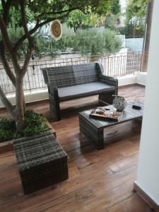um pátio com um sofá, uma mesa e uma árvore em Argostoli Elia's Maisonette em Argostólion