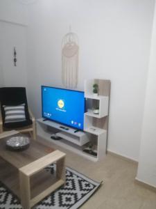 uma sala de estar com uma televisão de ecrã plano e uma cadeira em Argostoli Elia's Maisonette em Argostólion