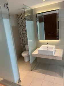 La salle de bains est pourvue d'un lavabo, de toilettes et d'un miroir. dans l'établissement D Majestic Hosted By TCL Home 4141, à Kuala Lumpur