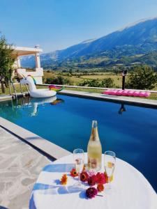 una mesa con dos copas y una botella de vino en Villa Xheni, 