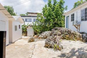 a house with a pile of rocks in the driveway at Negril's Hidden Gem With Modern Amenities in Negril