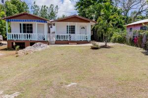 a house with a large yard in front of it at Negril's Hidden Gem With Modern Amenities in Negril
