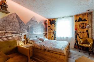 a bedroom with a bed with a mural of the pyramids at PARADiSE Wellness Residence in Terchová