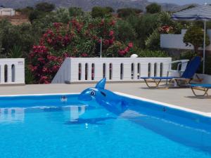 a statue of a dolphin in a swimming pool at Villas Michalis in Chorafakia