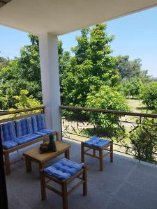 a balcony with two couches and a table and chairs at Tropical Garden Prime Accommodation in Faliraki