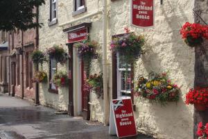 a street with flowers on the side of a building at Highland House Callander in Callander