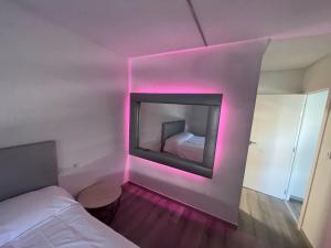 a room with a fireplace and a bed with pink lights at LA Lujuria in Ourense