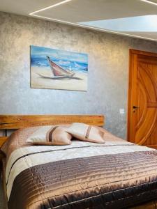 a bedroom with a bed with a painting on the wall at BRIVIBAS RESIDENCE - WAVE, free PRIVAT parking, free WIFI, self check-in in Riga