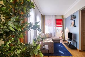 - un salon avec un canapé et une grande plante dans l'établissement Apartment wit, à Istanbul