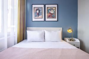 - une chambre dotée d'un mur bleu et d'un lit avec des oreillers blancs dans l'établissement Apartment wit, à Istanbul