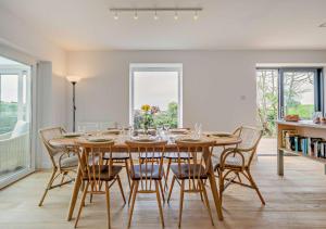 a dining room with a wooden table and chairs at Sea View in Morwenstow