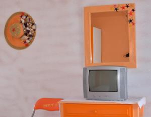 a tv sitting on top of a dresser with a mirror at Studios Soula in Alonnisos