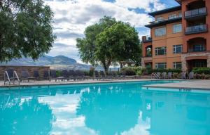 a swimming pool in front of a building at Watermark Beach Resort in Osoyoos