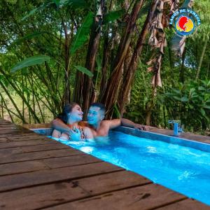 two people sitting in a swimming pool in a resort at Glamping Lagos de Venecia in Santa Rosa de Cabal