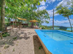 a pool with a view of the ocean and trees at Pinilla Highlands Incredible Mountain Ocean views in Tamarindo