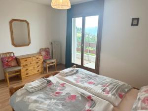 a bedroom with a bed and a mirror and a window at Résidence « Les Crêtes » in Torgon