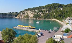 a yellow boat is docked at a dock in the water at Studios Soula in Alonnisos