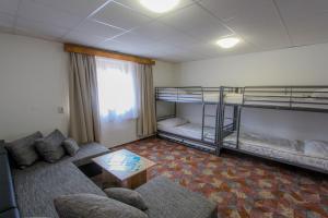 ein Wohnzimmer mit 2 Etagenbetten und einem Sofa in der Unterkunft Chata Biela Stopa in Tatranská Lomnica