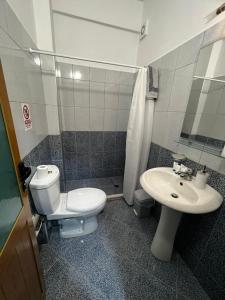 a bathroom with a toilet and a sink at Season Inn in Dhërmi
