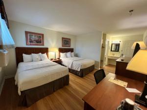 Habitación de hotel con 2 camas y escritorio en Inn at Cemetery Hill en Gettysburg