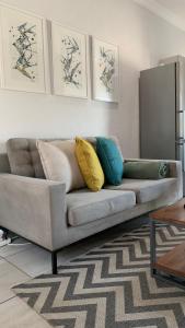 sala de estar con sofá y almohadas en CALDESMO Private Apartment en Pretoria