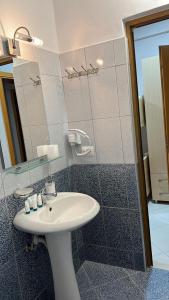 a bathroom with a sink and a mirror at Season Inn in Dhërmi