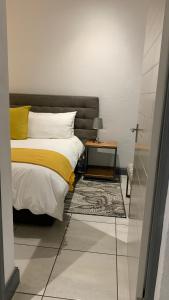 1 dormitorio con 1 cama y mesa auxiliar en CALDESMO Private Apartment en Pretoria