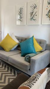 sala de estar con sofá y almohadas coloridas en CALDESMO Private Apartment en Pretoria